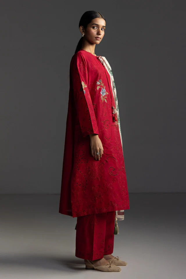 Woman wearing a red traditional outfit with floral embroidery on a gray background