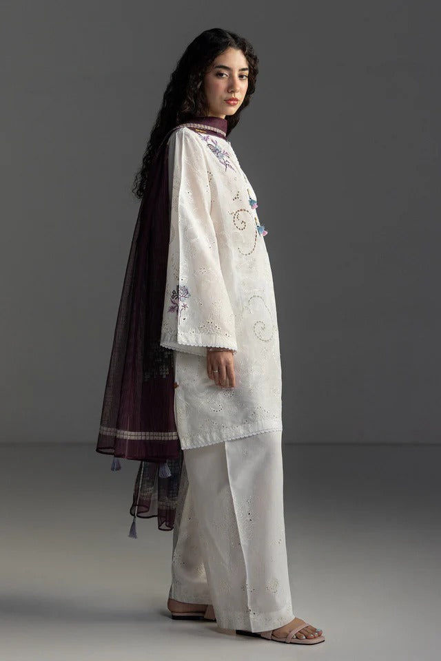 Woman wearing a traditional outfit with embroidery on a gray background
