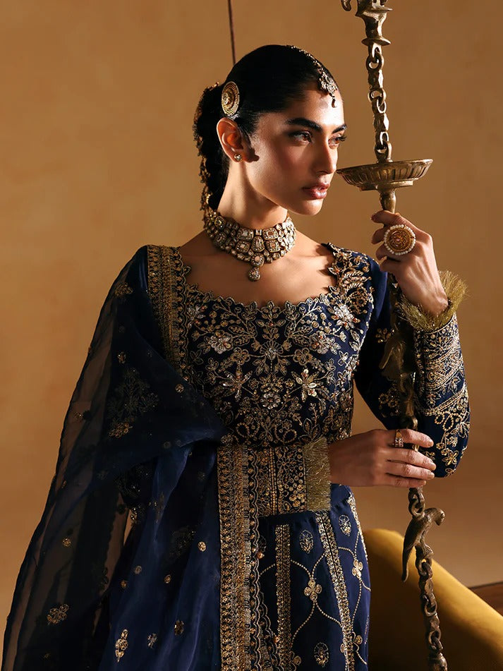 Woman in traditional embroidered outfit holding a decorative lamp against a warm background