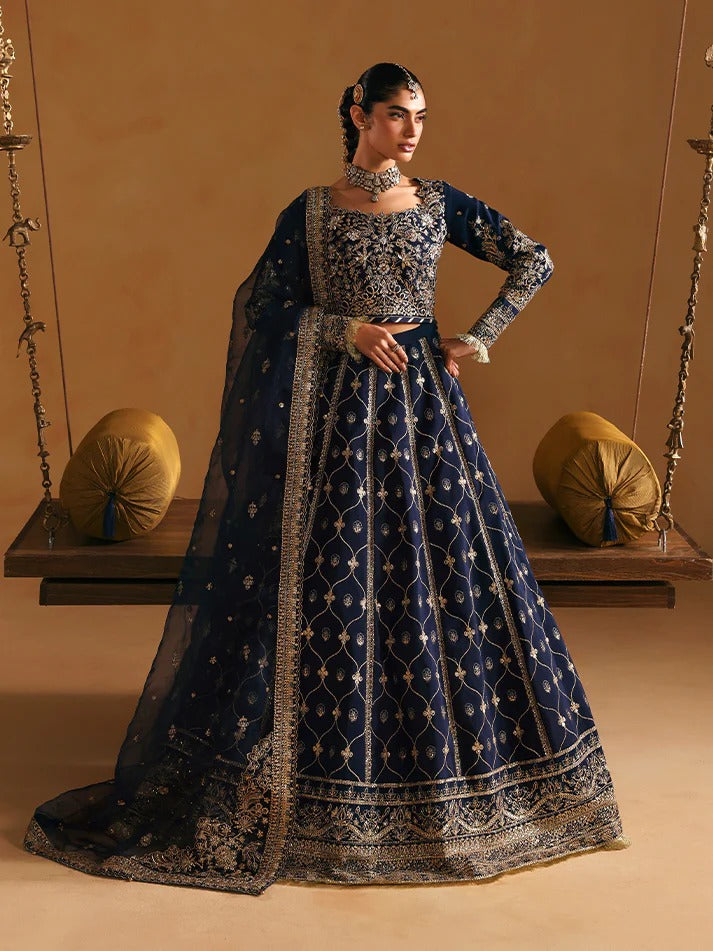 Woman in a traditional embroidered blue and silver outfit on a swing against a beige background
