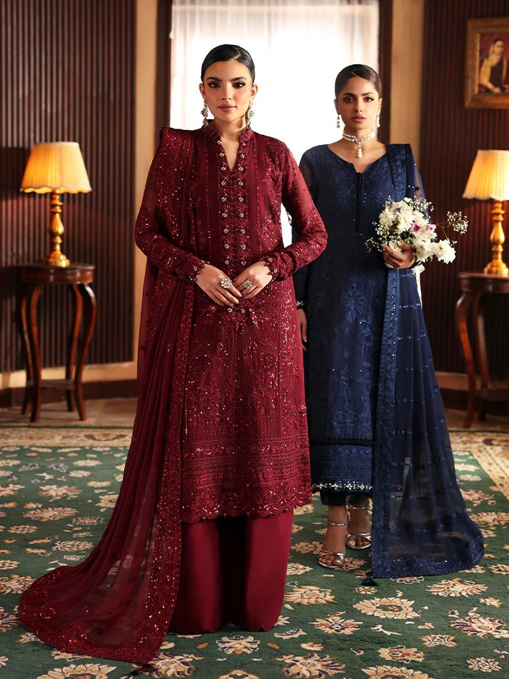 Two women in traditional outfits standing in a room with decorative elements.
