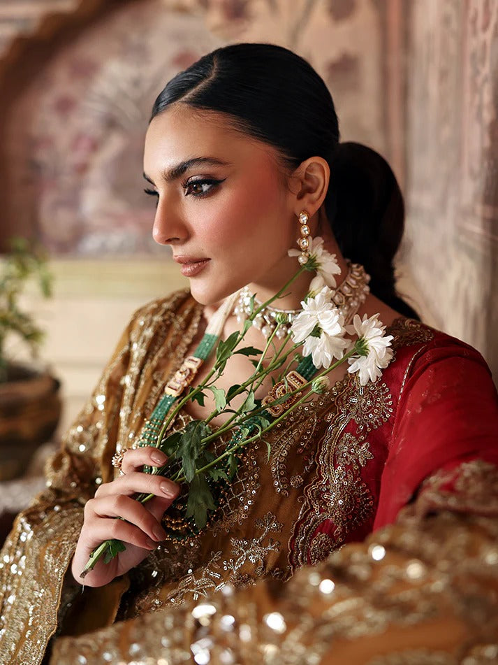 Woman in traditional attire holding flowers with a decorative background