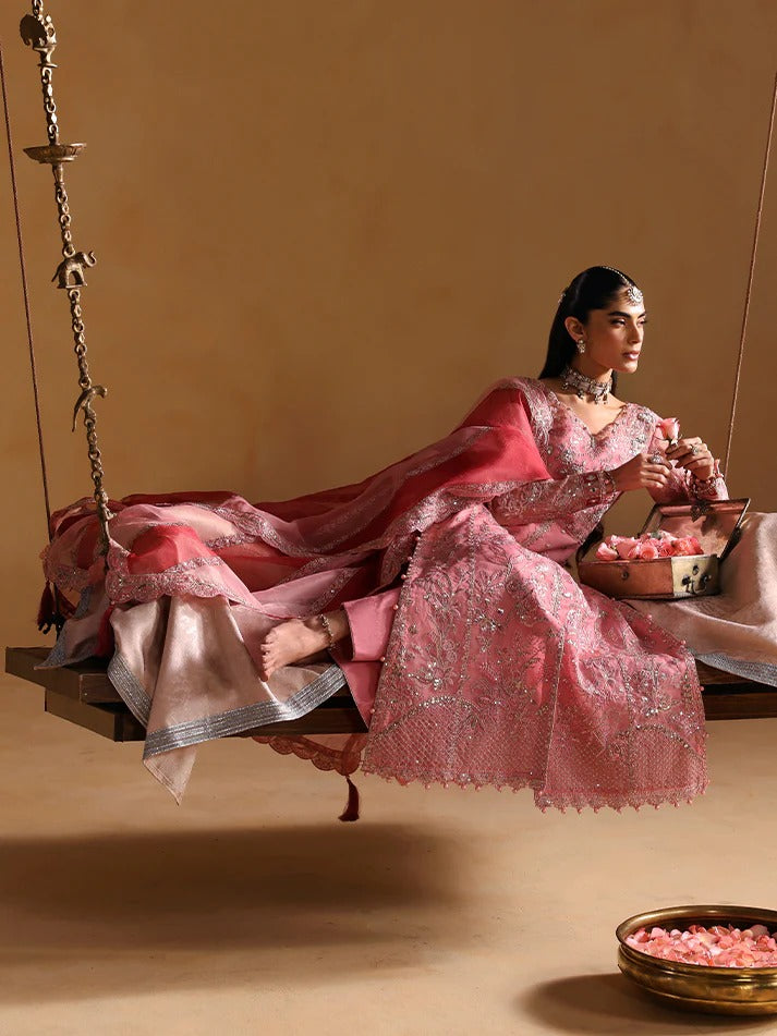Woman in a pink traditional outfit sitting on a swing with a beige background