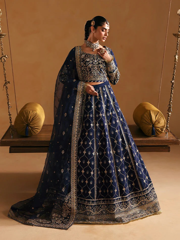 Woman in traditional blue embroidered outfit sitting on a swing against a beige background