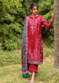 Woman in a red traditional outfit with a patterned shawl standing outdoors.