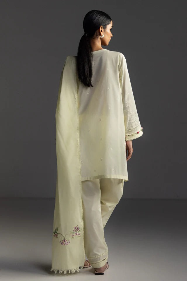 Woman wearing a light green traditional outfit with a plain background