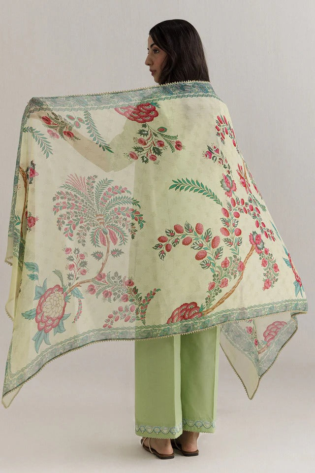 Woman wearing a floral-patterned shawl over her shoulders with a plain background