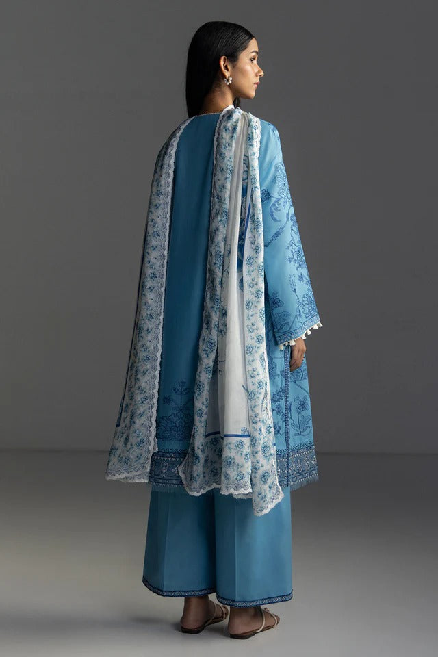 Woman wearing a blue traditional outfit with a white dupatta against a gray background