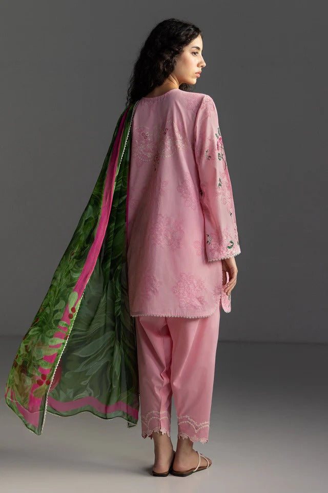 Woman wearing a pink traditional outfit with a green dupatta against a gray background