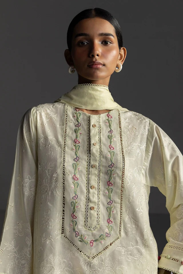 Woman wearing a cream-colored embroidered kurta against a dark background
