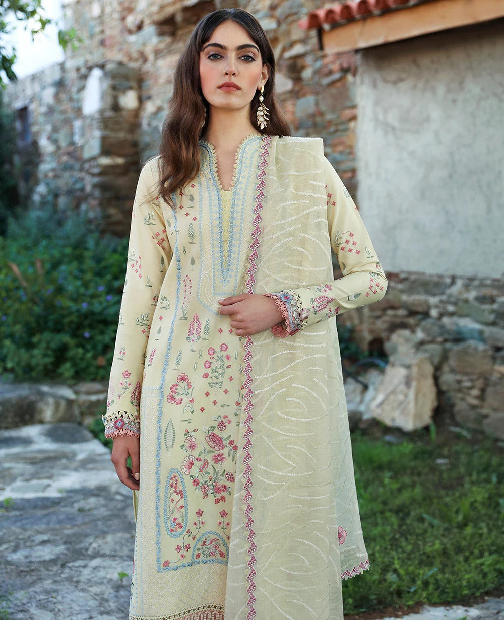 Woman wearing a light-colored embroidered dress in an outdoor setting.
