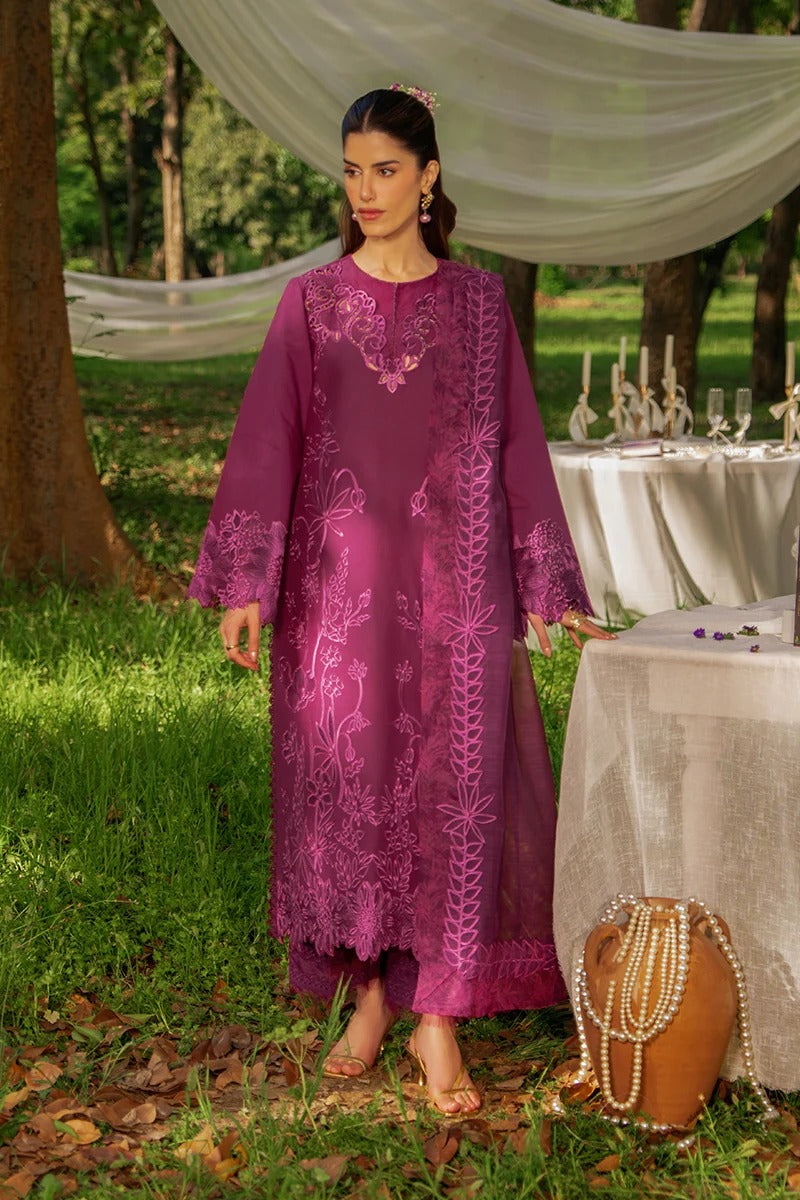 Woman in a purple embroidered dress standing outdoors near a decorated table.