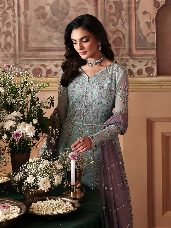 Woman in traditional attire with floral decorations and a candle in an ornate room.