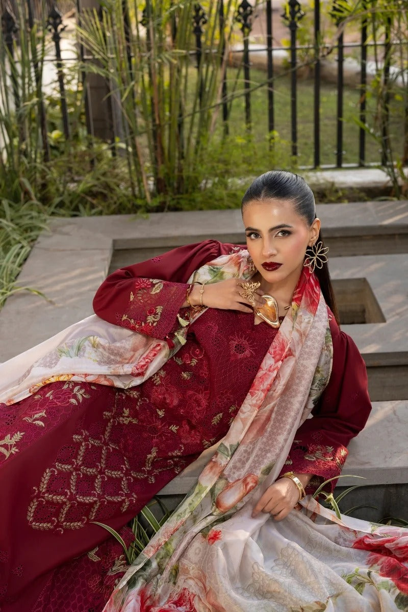 Woman in traditional red and white embroidered outfit sitting outdoors.