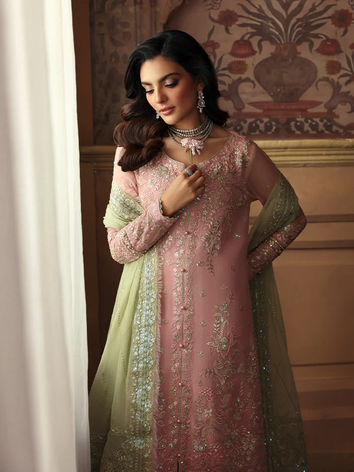 Woman in a traditional outfit with intricate designs in a decorated room.