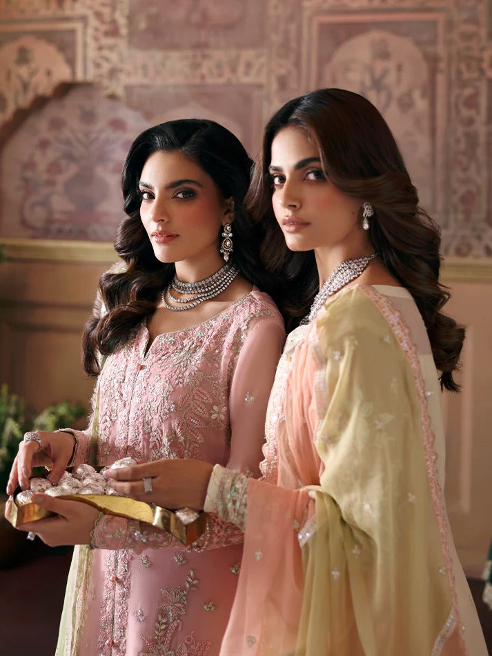 Two women in traditional attire standing in a decorated room.