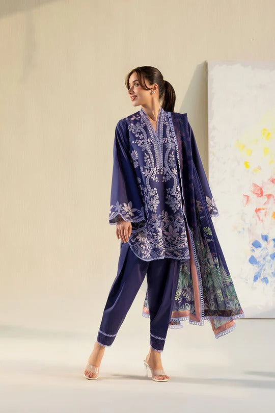 Woman wearing a dark blue embroidered outfit with a light background