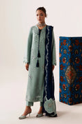 A model wears a traditional three-piece salwar kameez suit in mint green and navy blue. The long kurta features silver mirror embroidery, paired with matching trousers and a navy blue dupatta with silver borders and tassels.
