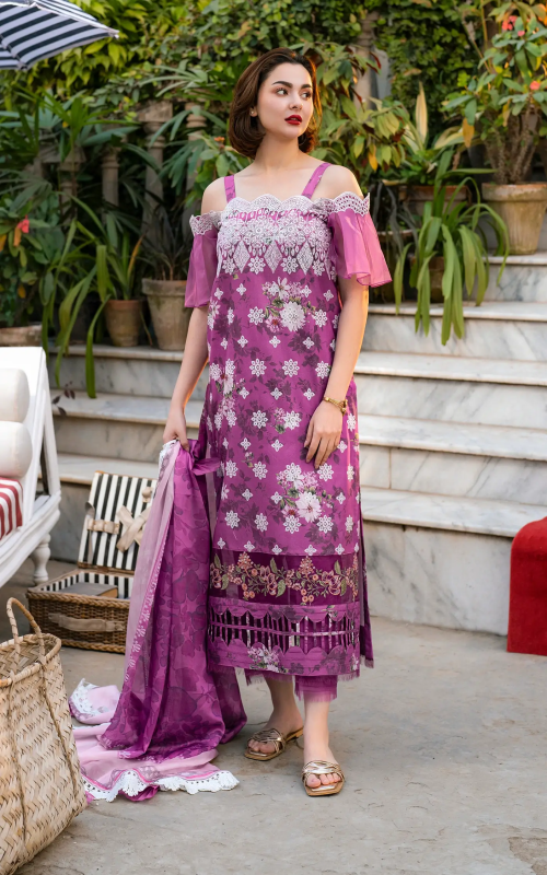 Woman in a pink and purple floral dress standing outdoors with plants and furniture in the background