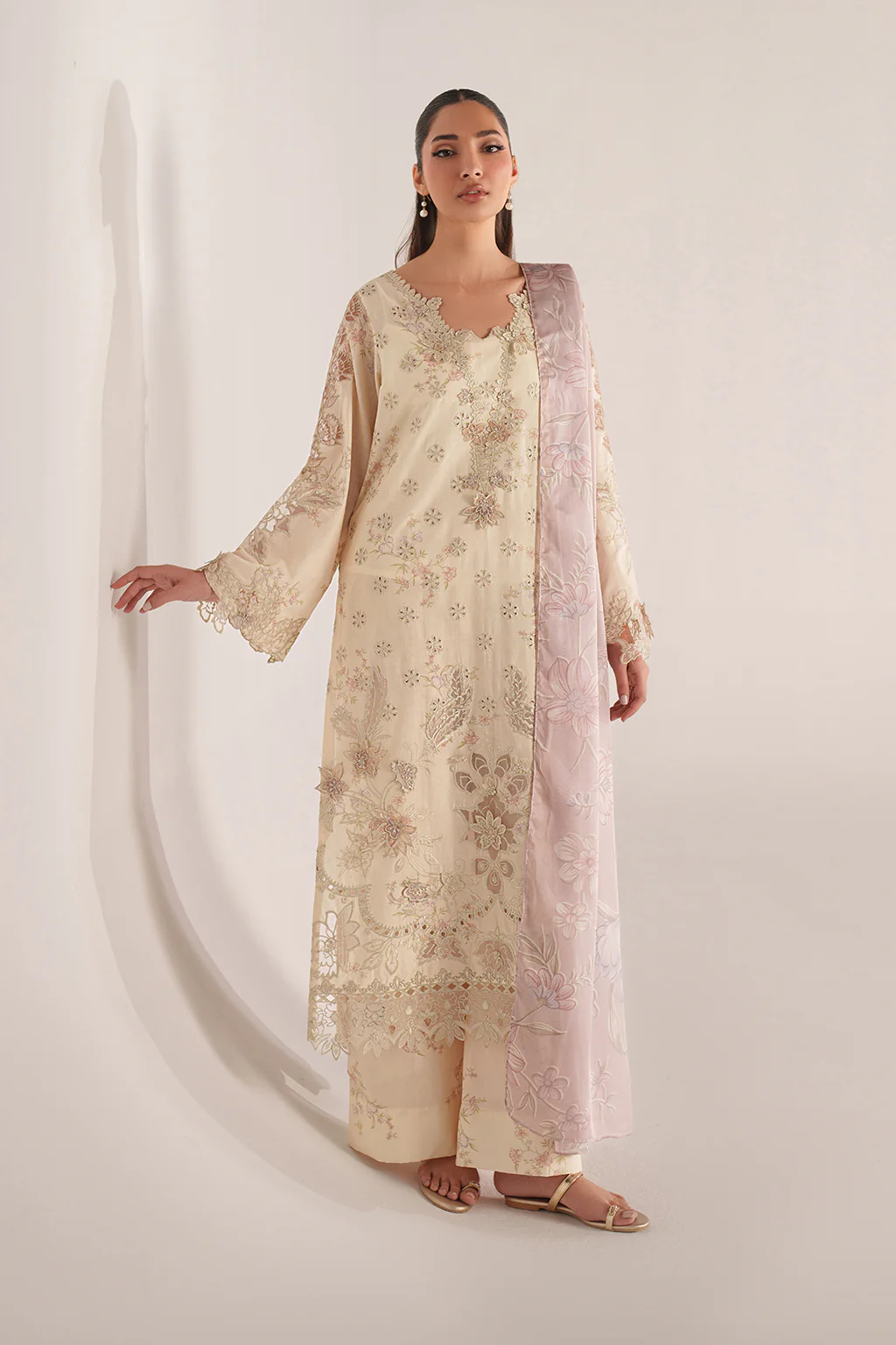 Woman wearing a floral kurta with a matching dupatta on a white background
