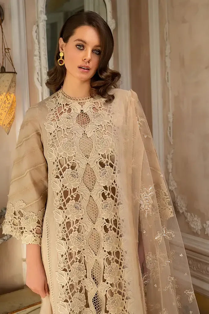 Woman wearing a beige embroidered outfit with a matching dupatta in an indoor setting.