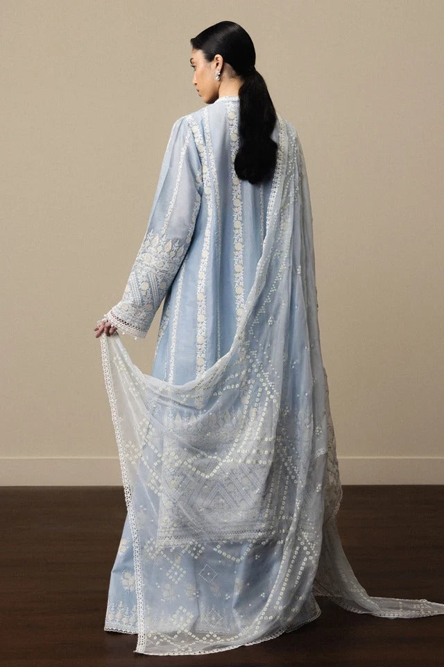 Woman holding a light blue embroidered dupatta against a beige background
