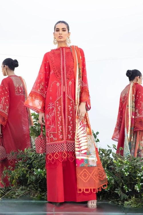 A model wearing a red embroidered traditional South Asian outfit with a matching dupatta, standing in front of a white background with other models partially visible.