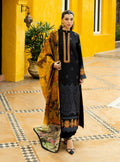 Woman in a black and yellow traditional outfit standing in front of a yellow wall.