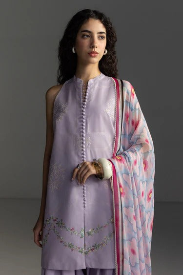 Woman wearing a light purple embroidered outfit with a matching dupatta against a gray background