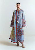 A model wearing a light blue three-piece salwar kameez suit with red and floral patterns, a matching dupatta, and light blue trousers, photographed against a plain white studio background.