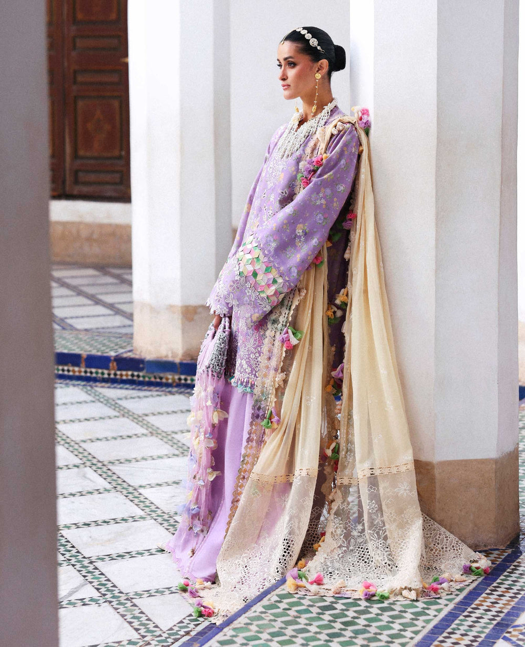 Woman in a traditional outfit with floral patterns on a decorative floor.