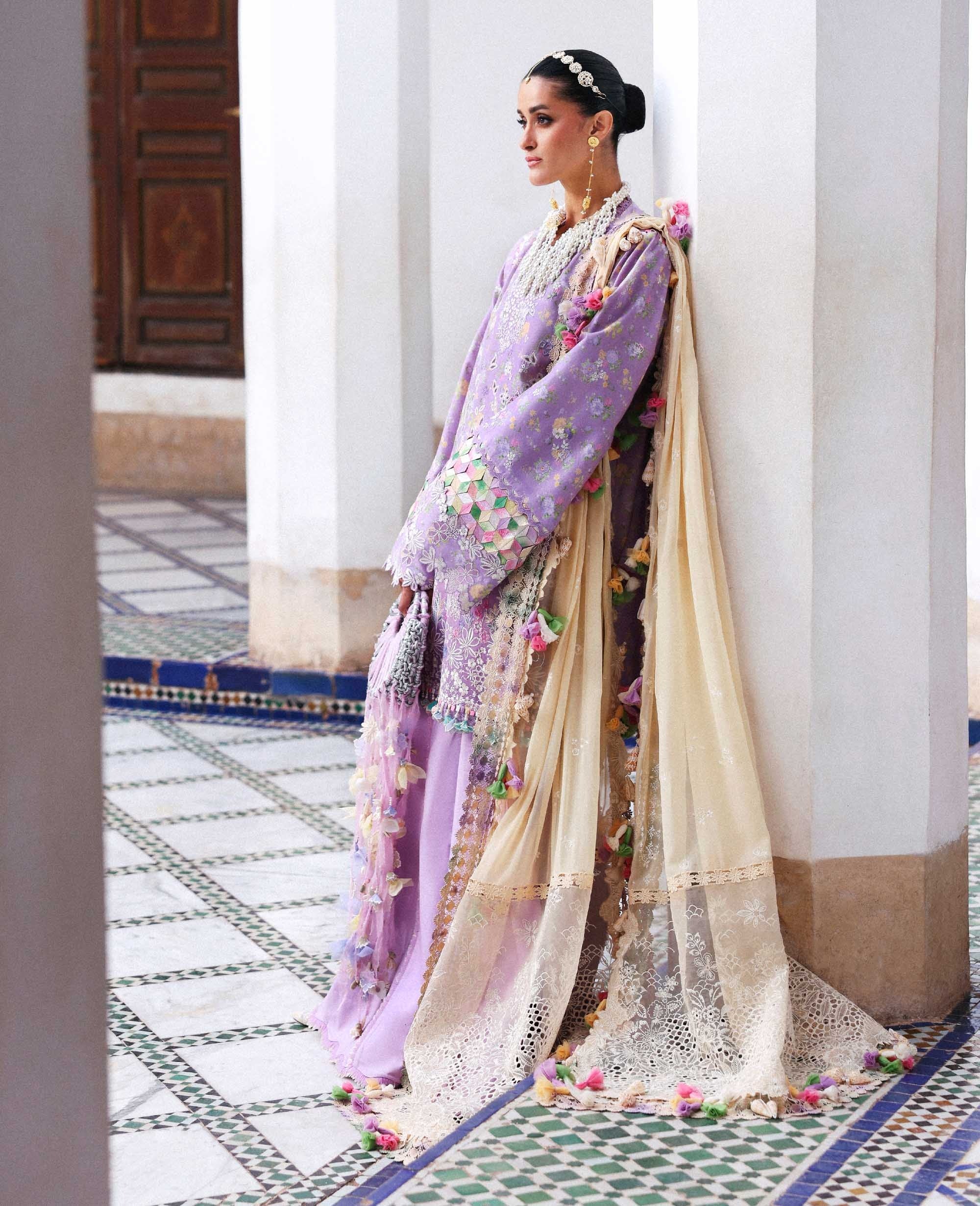 Woman in a traditional outfit with floral patterns on a decorative floor.