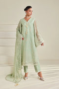 A woman models a mint green ethnic three-piece suit with white embroidery, featuring a long kurta, matching trousers, and a sheer dupatta, set against a neutral cream-colored background.