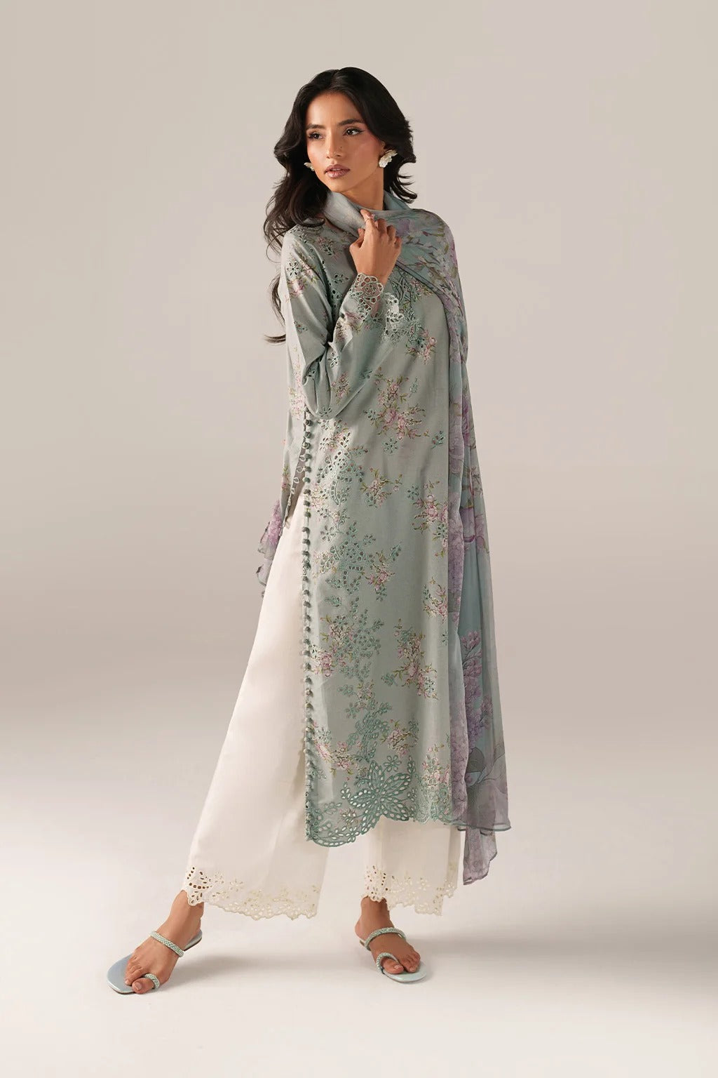 Woman wearing a floral dupatta over a white outfit on a light gray background