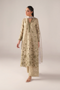 Woman wearing a beige floral kurta with palazzo pants on a light gray background