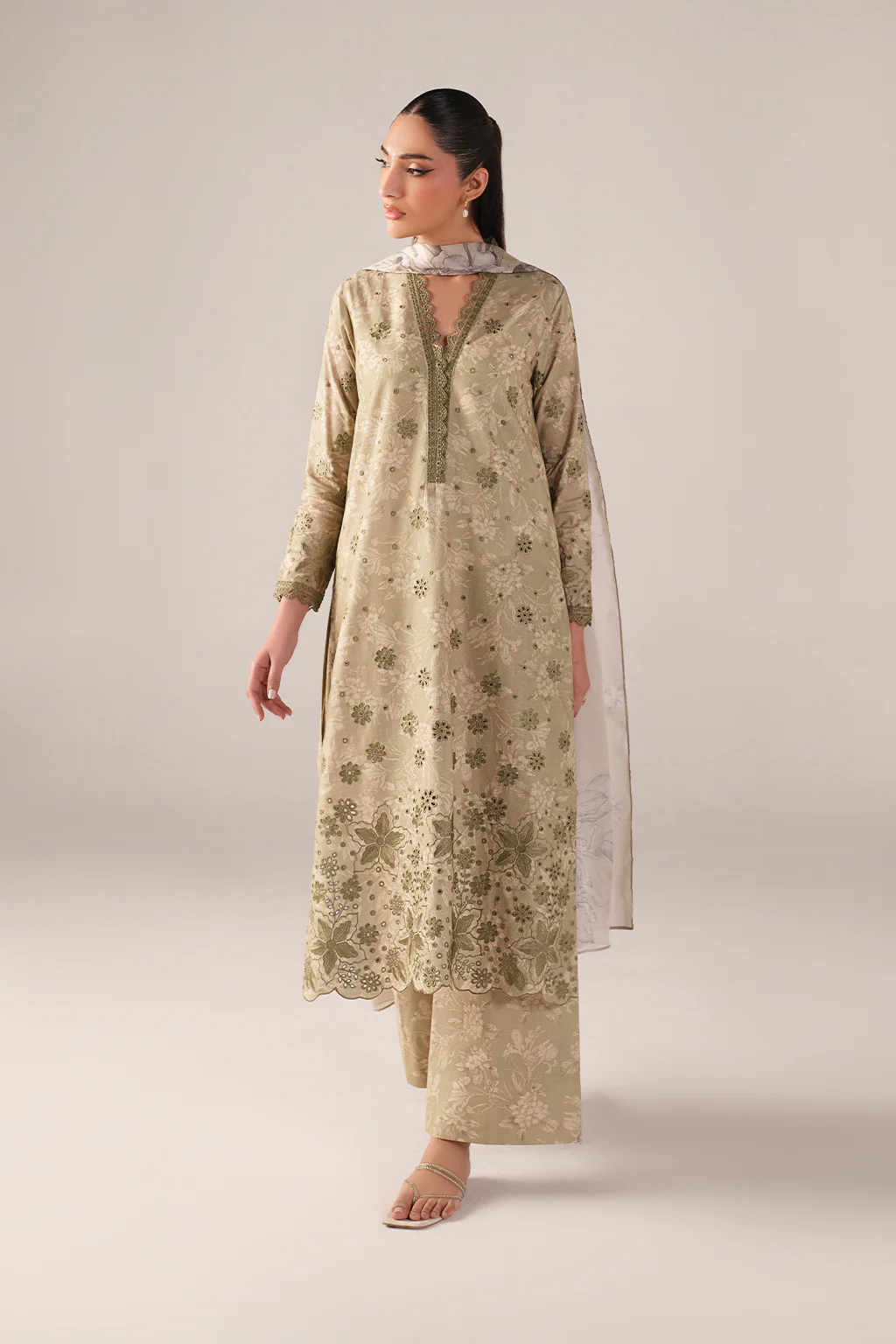Woman wearing a beige floral kurta with palazzo pants on a light gray background