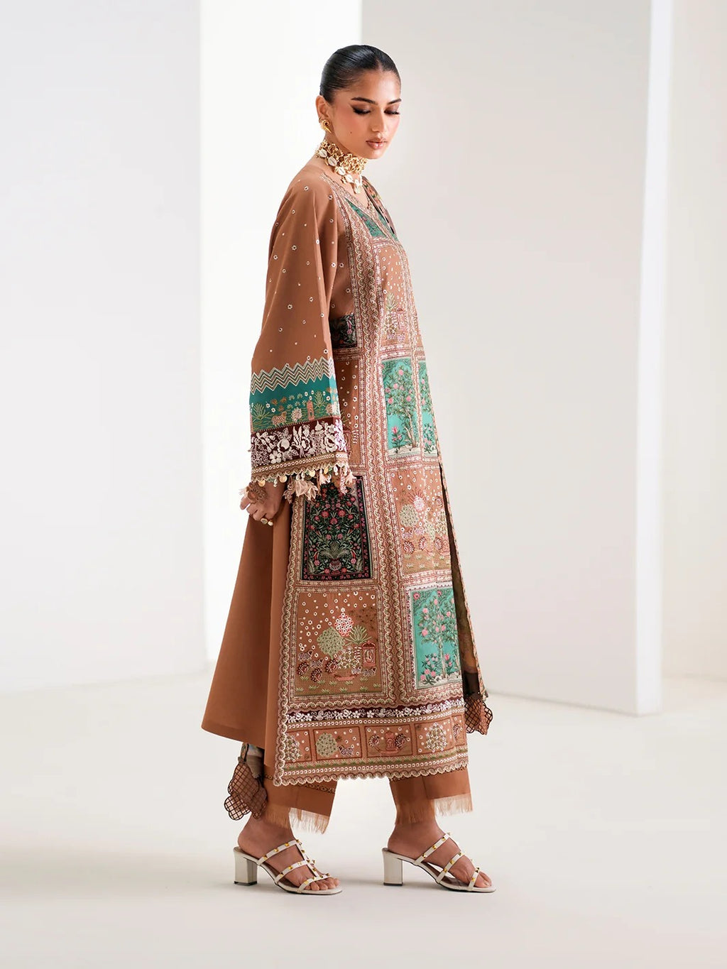 Woman wearing a traditional outfit with intricate patterns on a white background