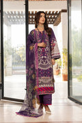 A woman models a traditional three-piece salwar kameez suit in purple, featuring intricate white and pink floral embroidery, printed patterns, and a matching sheer dupatta, set against a modern glass door background.