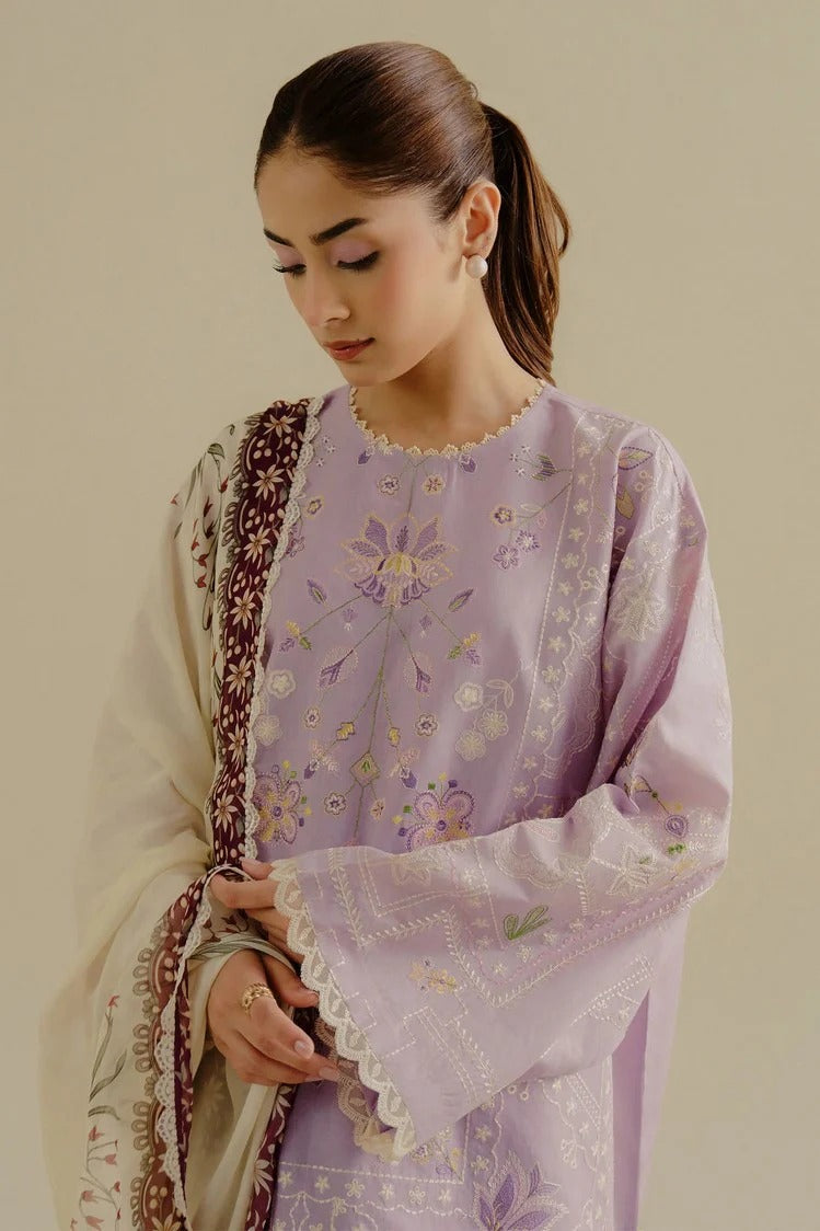 Woman wearing a light purple embroidered traditional outfit with a beige background
