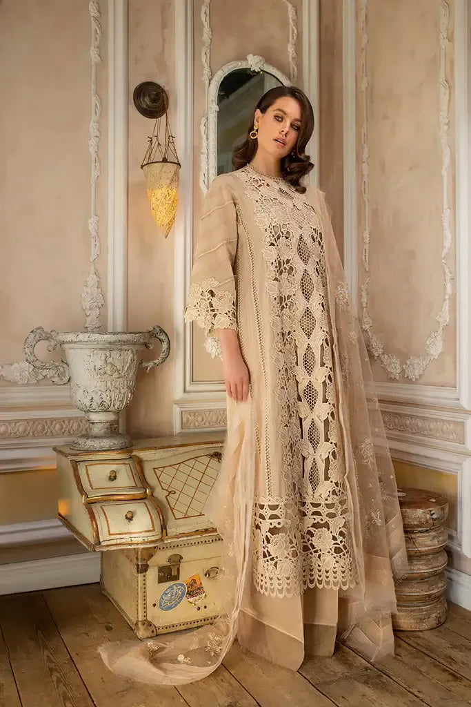 Woman in a beige lace dress standing in an elegant room with decorative elements.