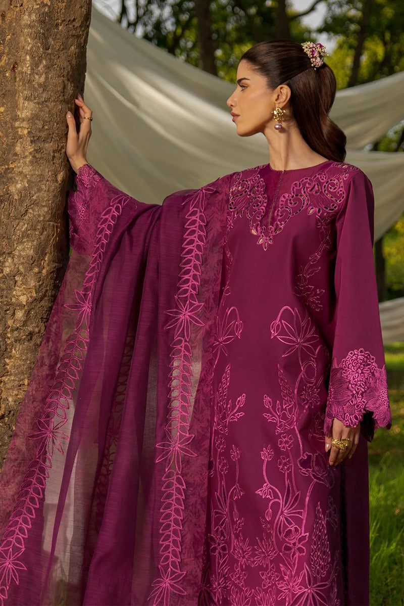 Woman in a purple embroidered outfit standing next to a tree