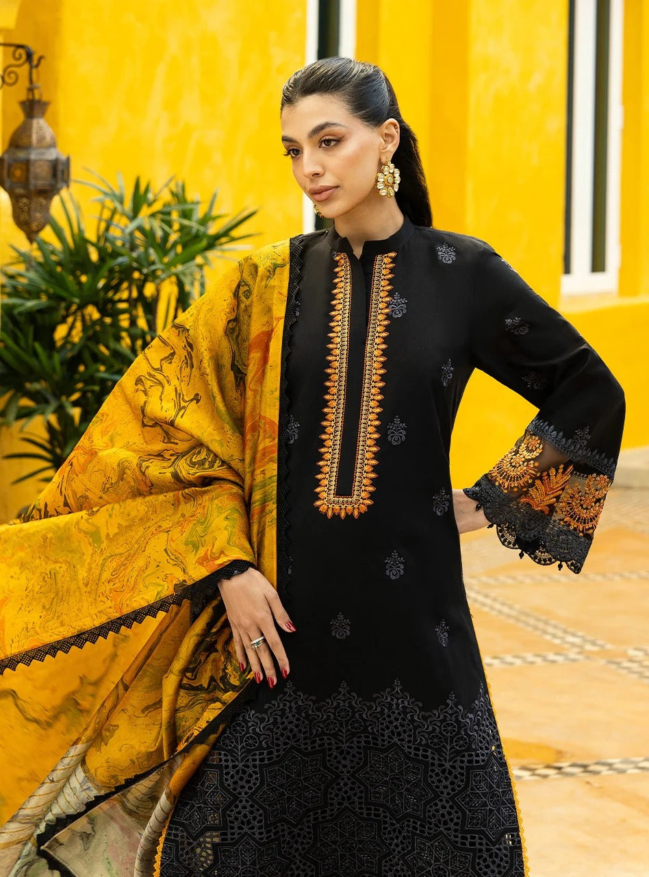 Woman wearing a black and yellow embroidered outfit against a yellow wall.