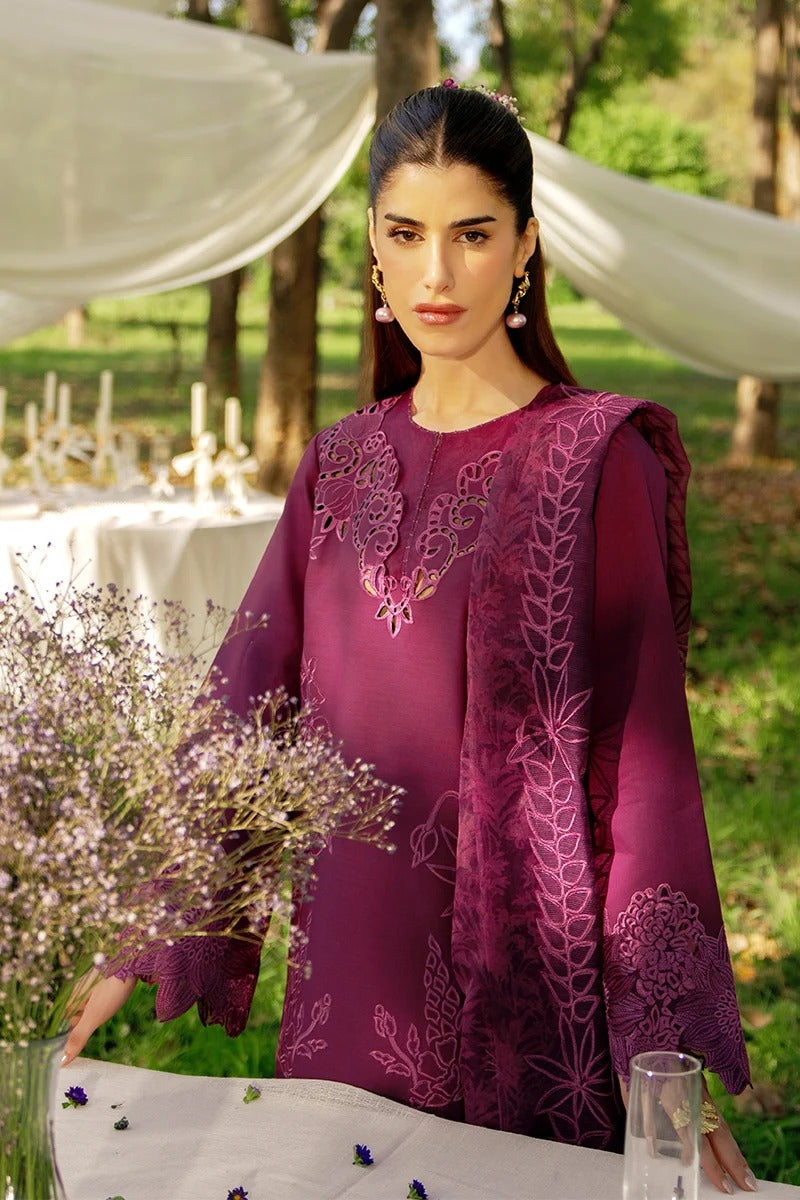 Woman in a purple embroidered dress standing outdoors with tables and decorations.
