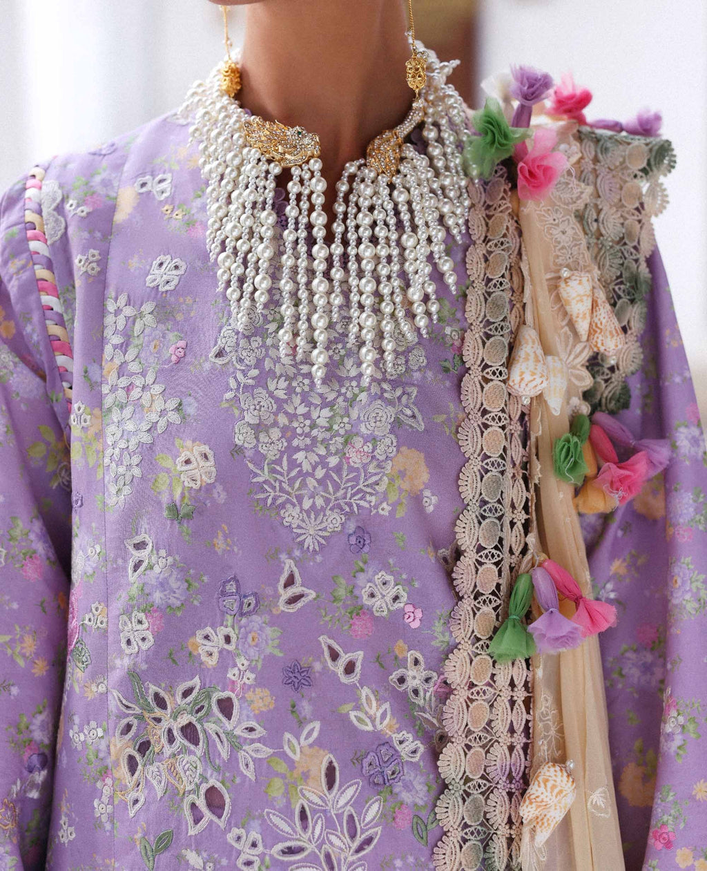 Traditional outfit with floral patterns and decorative elements on a white background