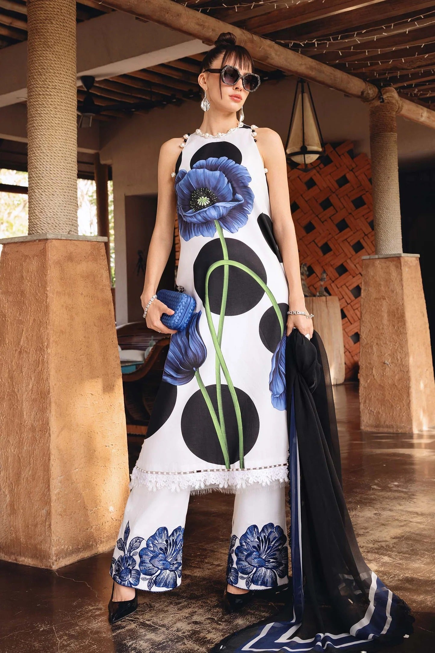 Woman wearing a floral dress with blue flowers in an indoor setting