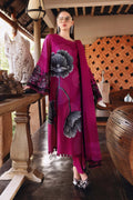 Woman in a vibrant pink dress with floral design standing in an outdoor setting.