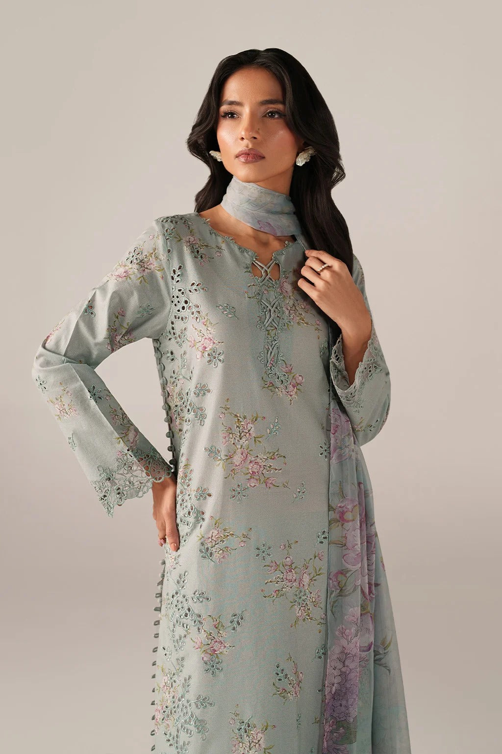 Woman wearing a light blue floral dress against a plain background