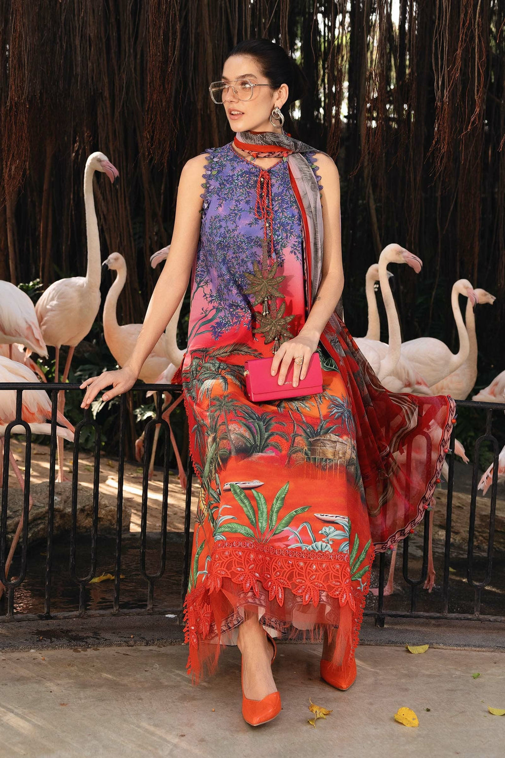 Woman in a colorful dress standing in front of flamingos
