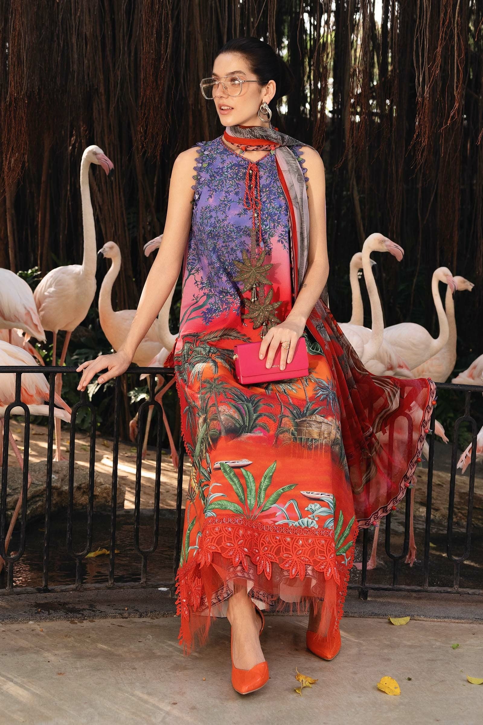 Woman in a colorful dress standing in front of flamingos