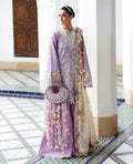 Woman in a traditional outfit with floral patterns in a decorative interior setting
